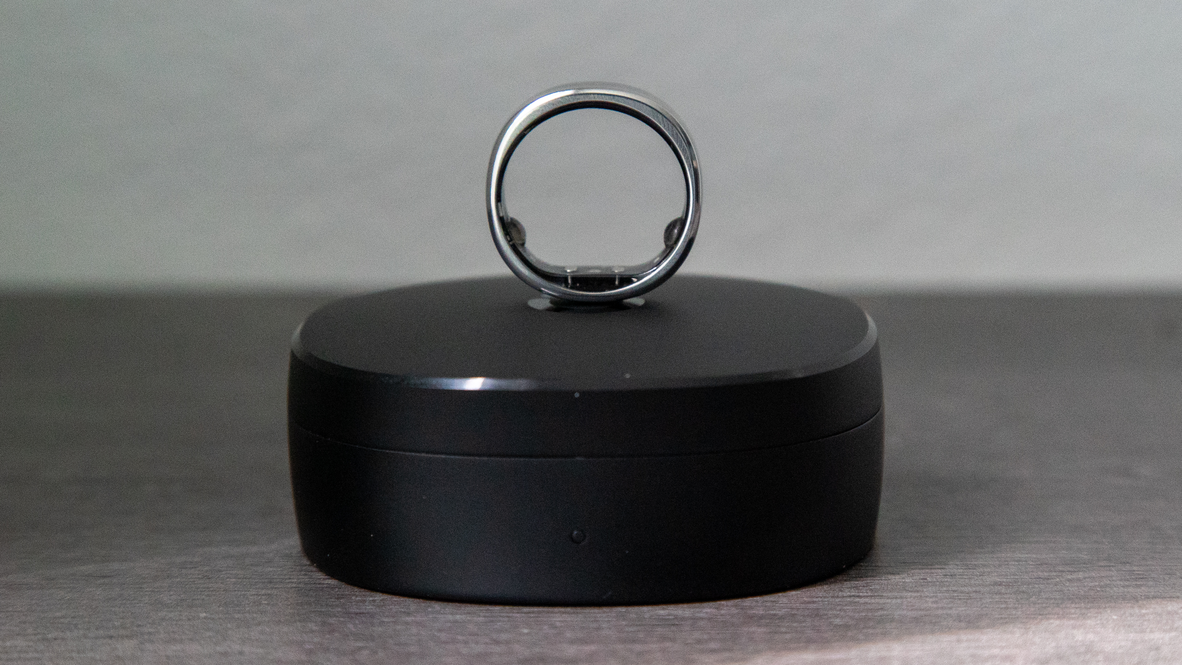 The RingConn Gen 2 Smart Ring balanced on its charging case