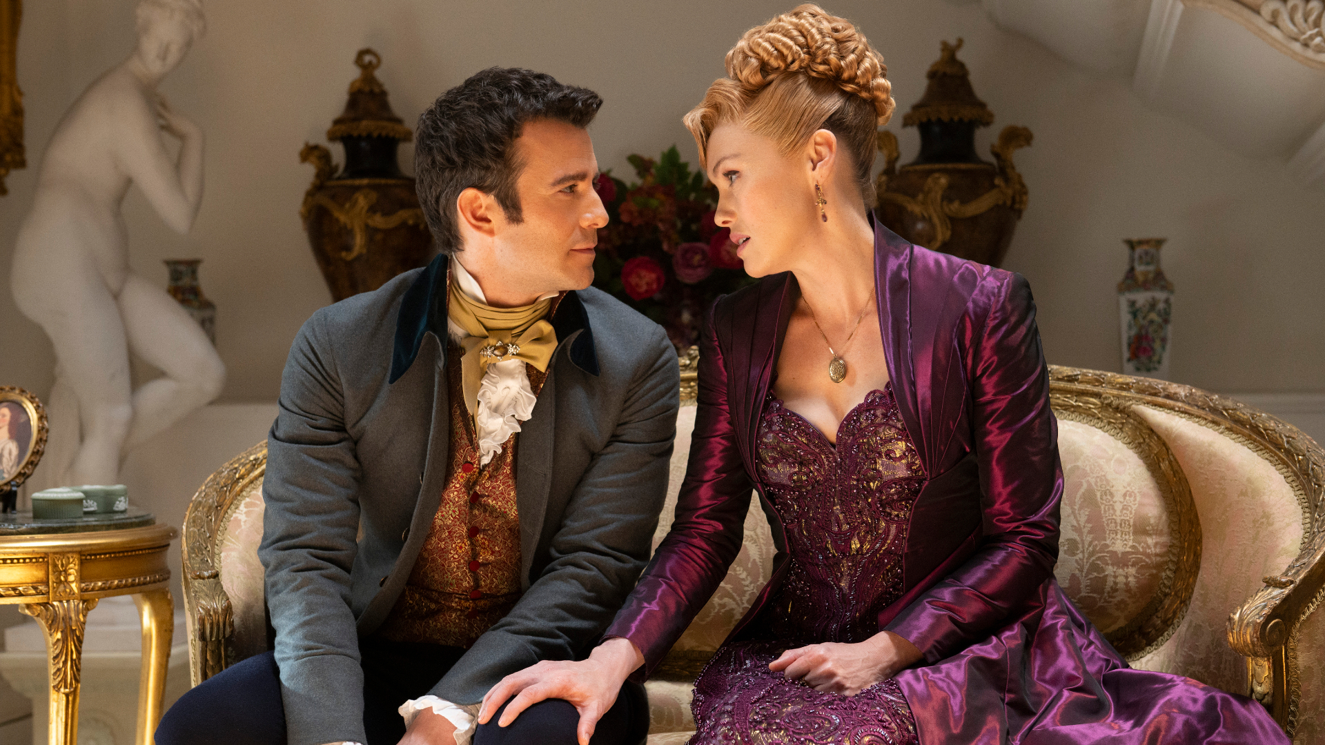 Benedict Bridgerton and Lady Tilley Arnold exchange glances while sat on a bench