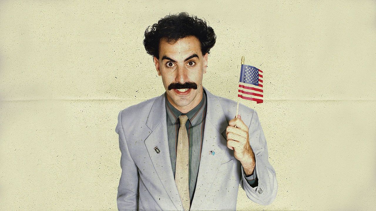 Sacha Baron Cohen as Borat holding an American flag