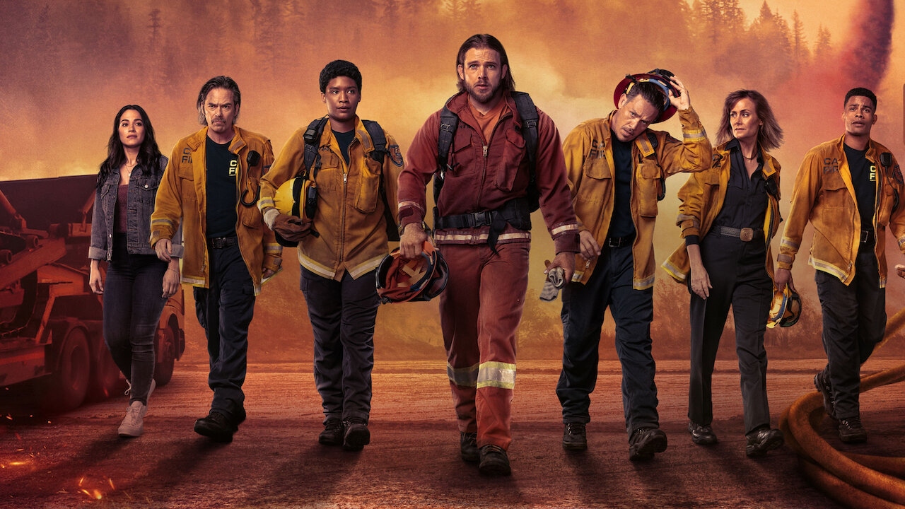 Fire Country cast standing in a line and walking towards the camera wearing firefighter gear.