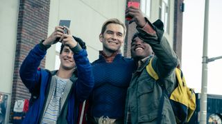 Homelander poses for a selfie with two fans.