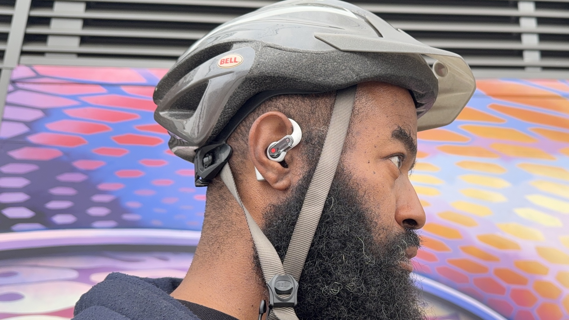 Tshaka wearing Nothing Ear (open) and a bike helmet