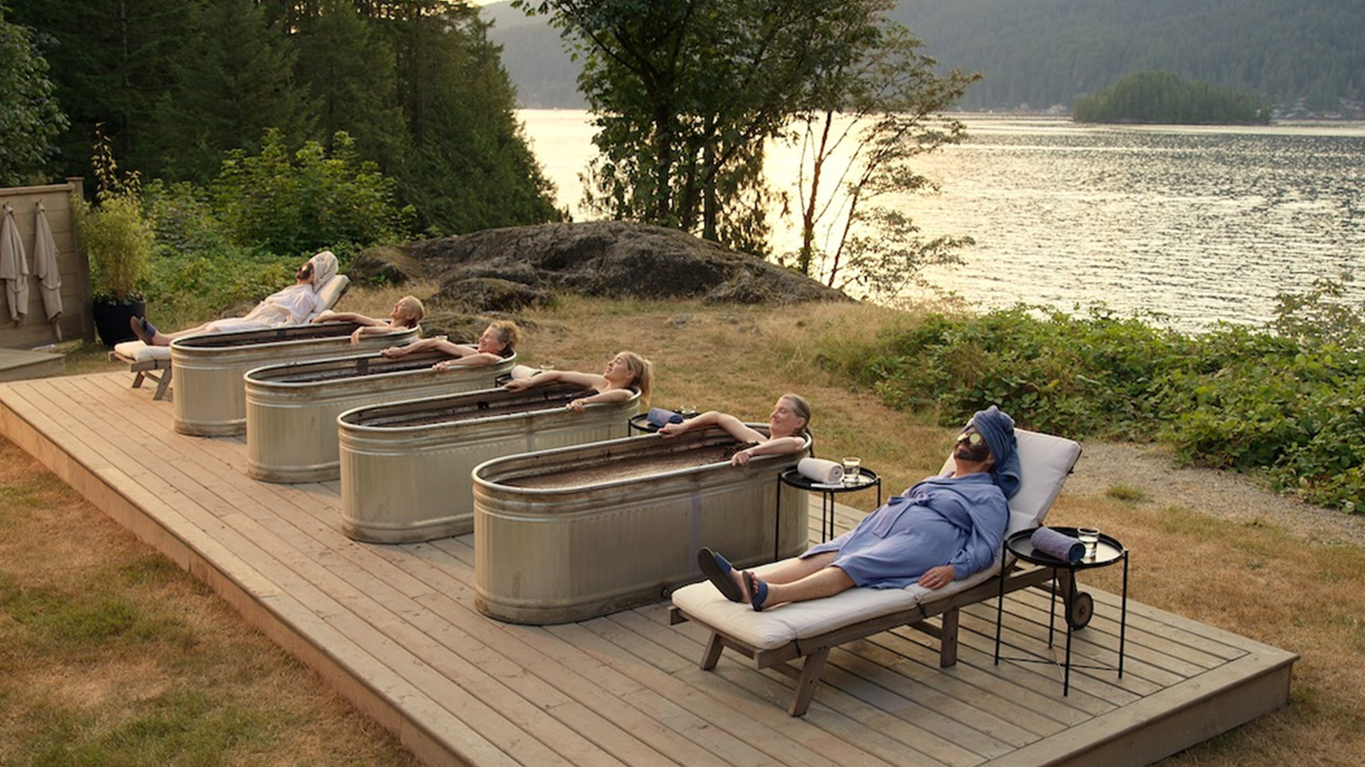 A row of bath tubs near the side of a lake