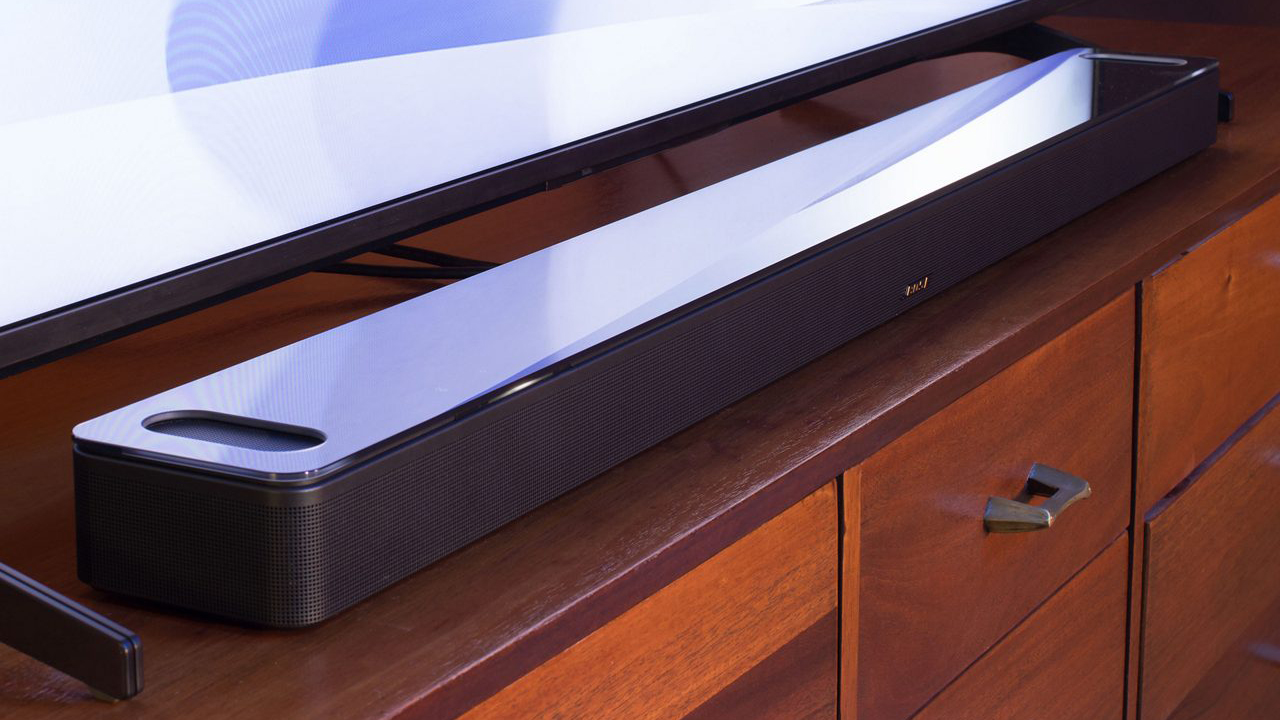 Bose Smart Ultra Soundbar sitting on table in front of TV in living room.