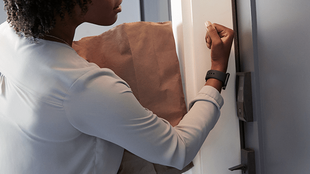 Person using smartwatch to open door with Schlage Encode Plus lock