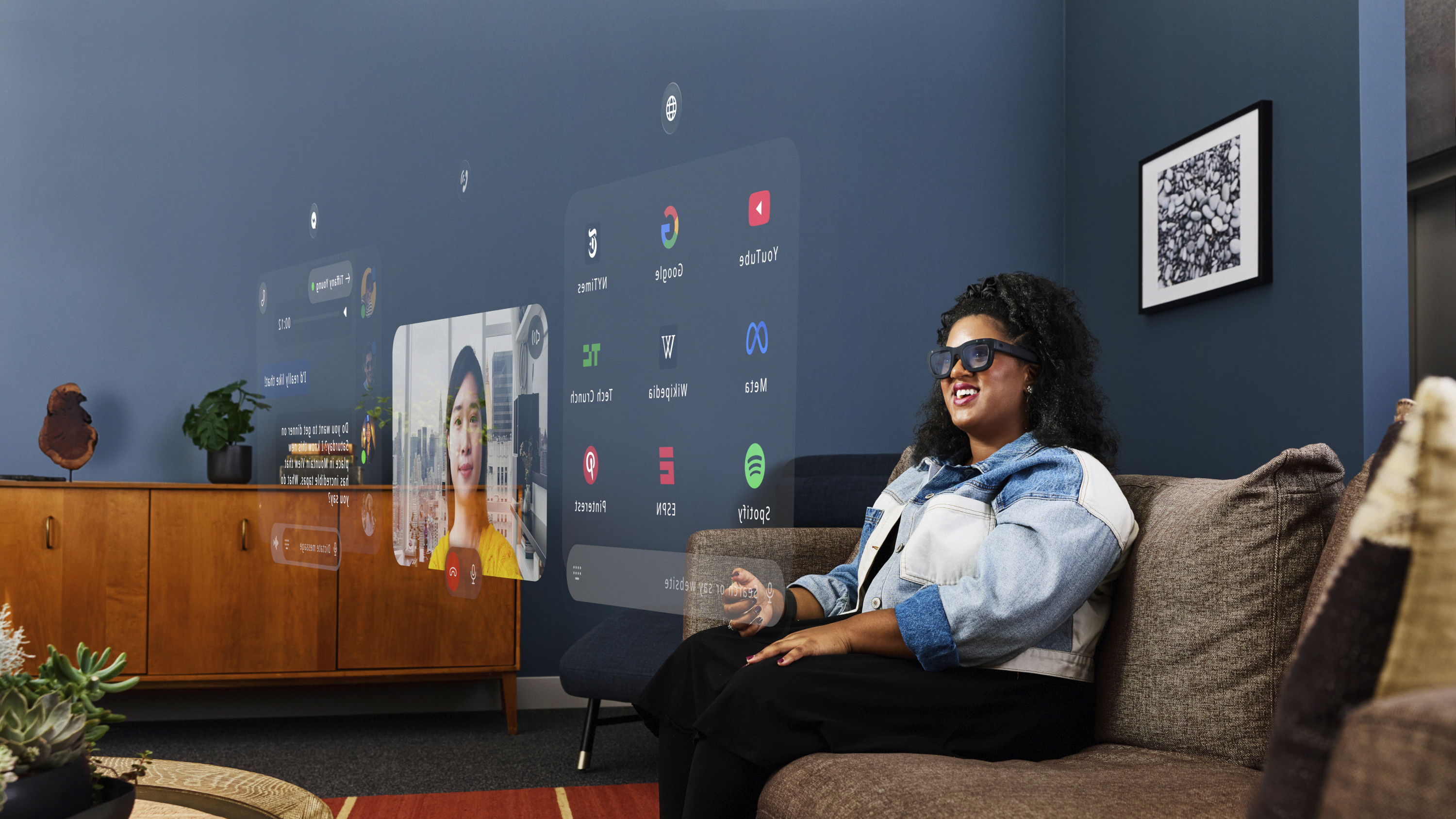 Press photo of a woman wearing the Meta Project Orion AR glasses and using the multitasking software.