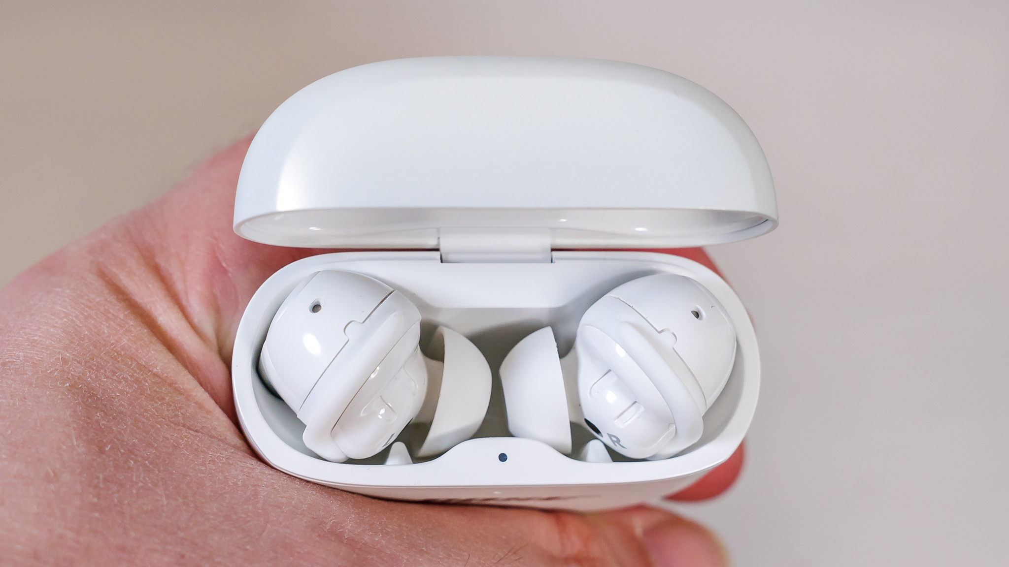 Open case showing the Bose QuietComfort Ultra Earbuds in hand.