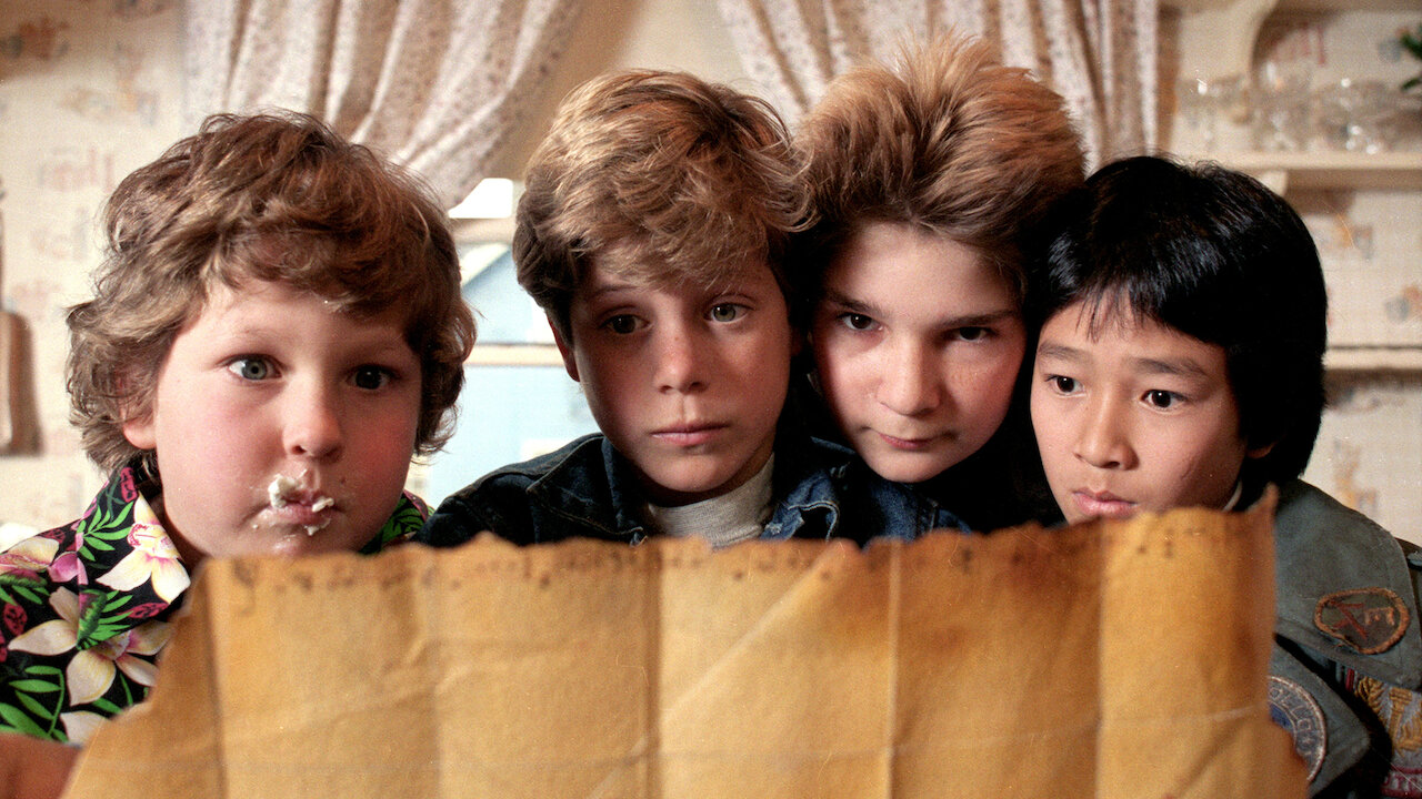 Chunk, Mikey, Mouth and Data read a treasure map in The Goonies