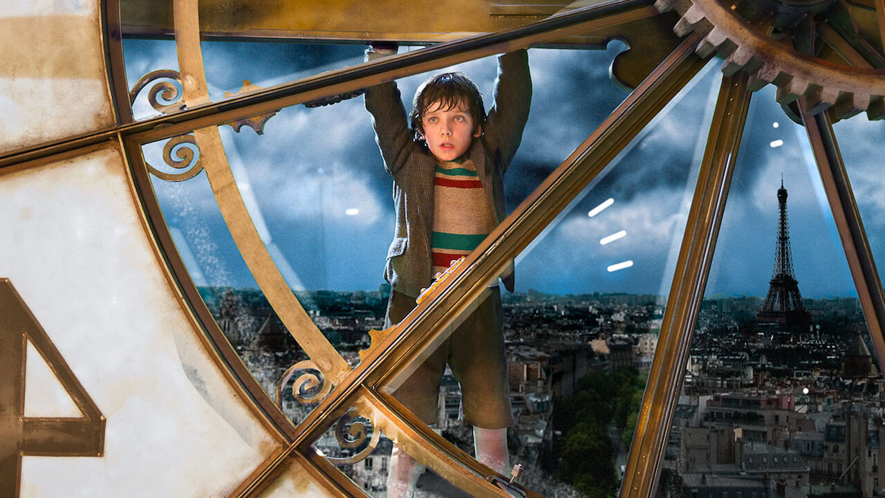 A screenshot of Hugo hanging from a clock in Martin Scorsese's Hugo movie