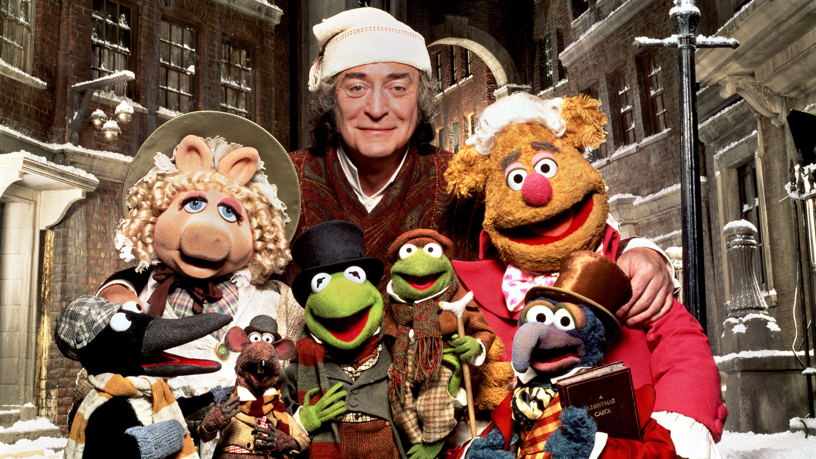 Michael Caine surrounded by Muppets in The Muppet Christmas Carol