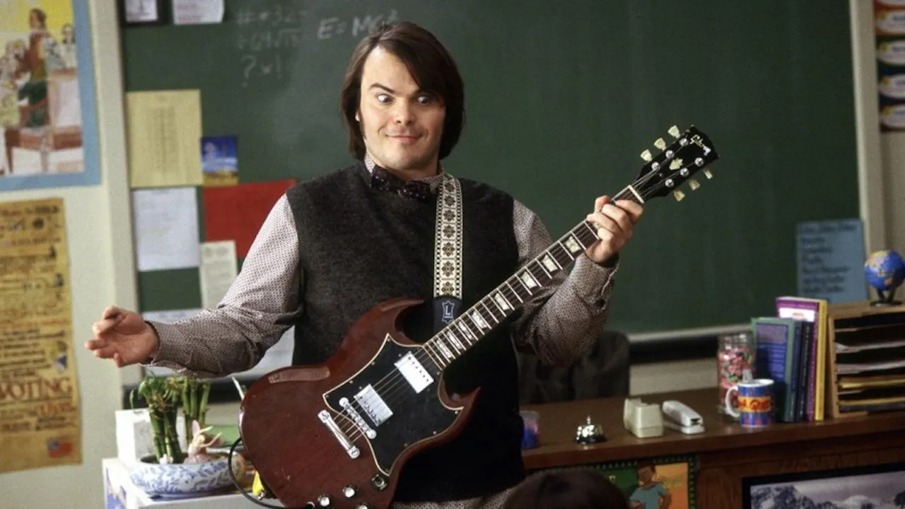 A promo shot for the movie School of Rock featuring Jack Black playing a guitar in a classroom.