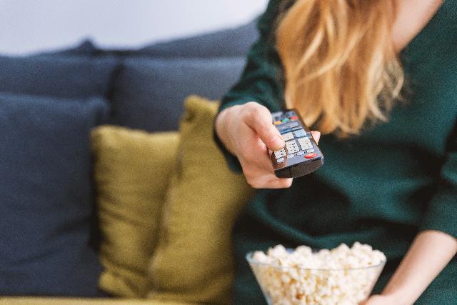 Woman with popcorn and remote