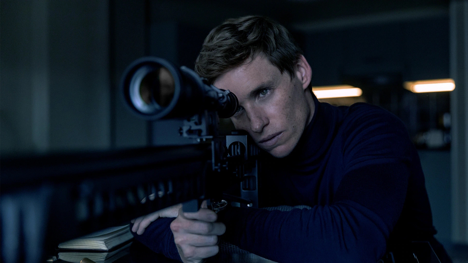 Eddie Redmayne preparing to take a shot with a sniper rifle in The Day of the Jackal.