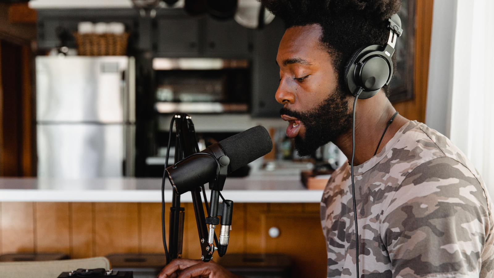 Man using microphone and audio editing software in home studio