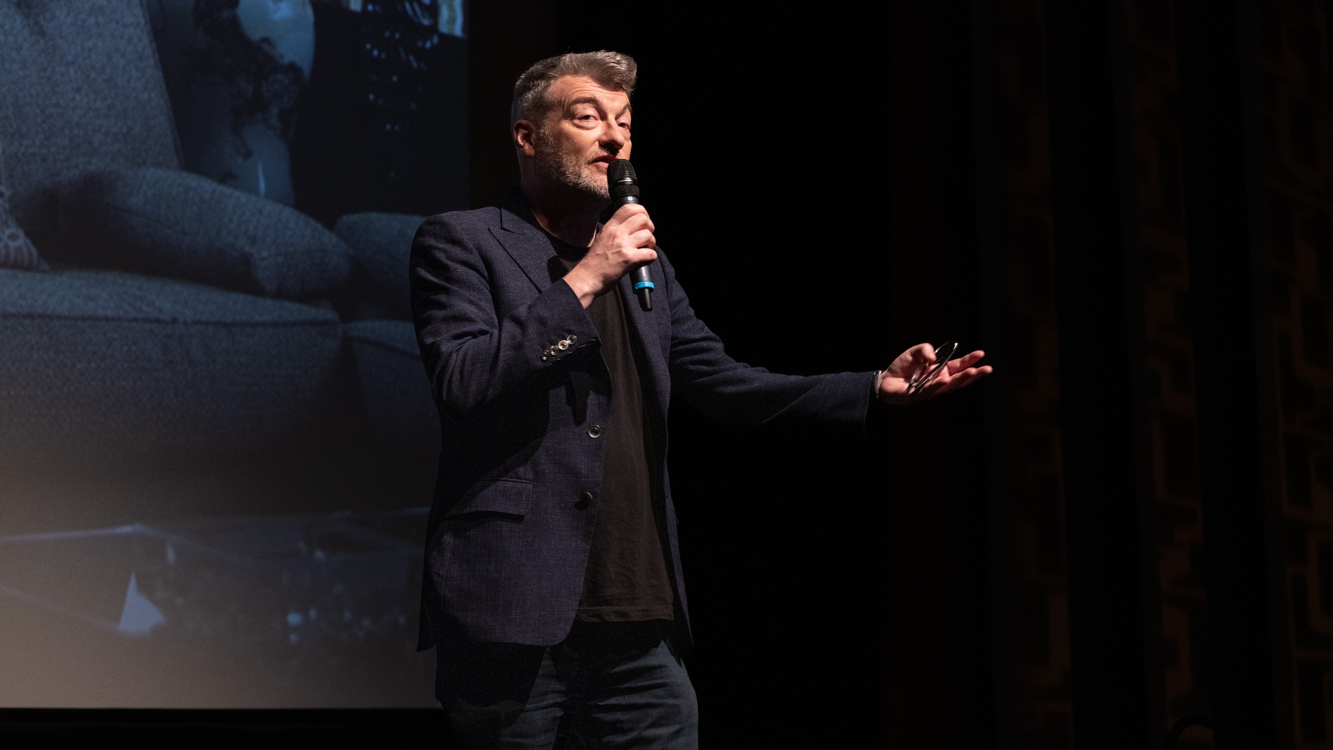 Charlie Brooker holds a microphone during a Black Mirror panel discussion