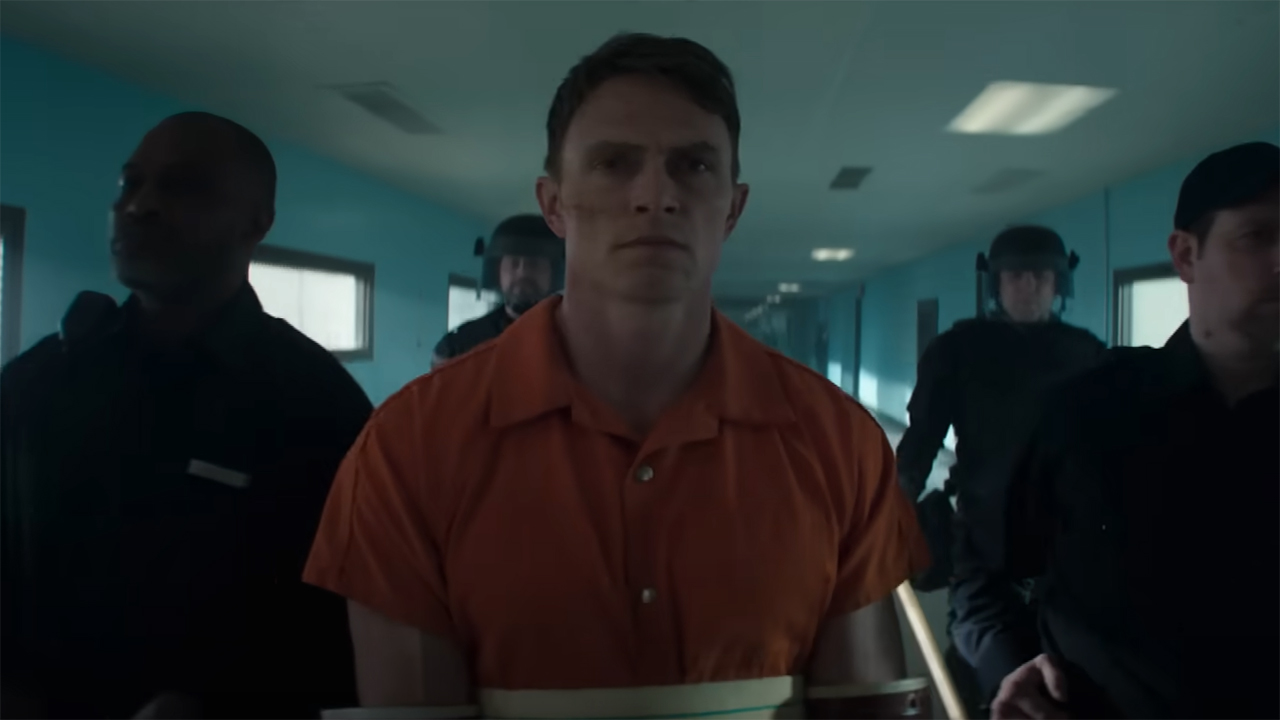 Benjamin 'Dex' Pointdexter walking down a prison corridor flanked by police officers in Daredevil: Born Again