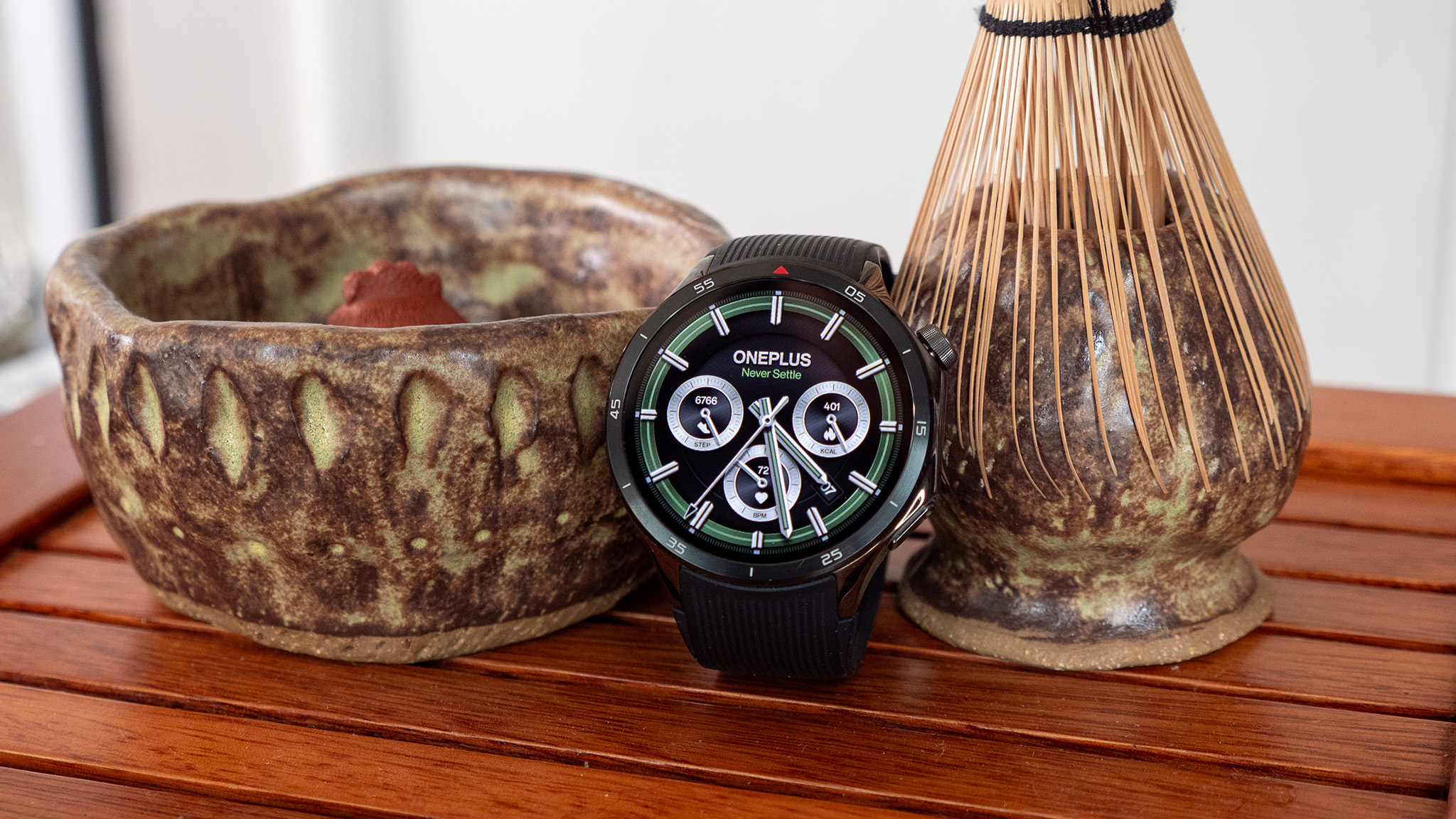 A OnePlus Watch 3 with a green watchface