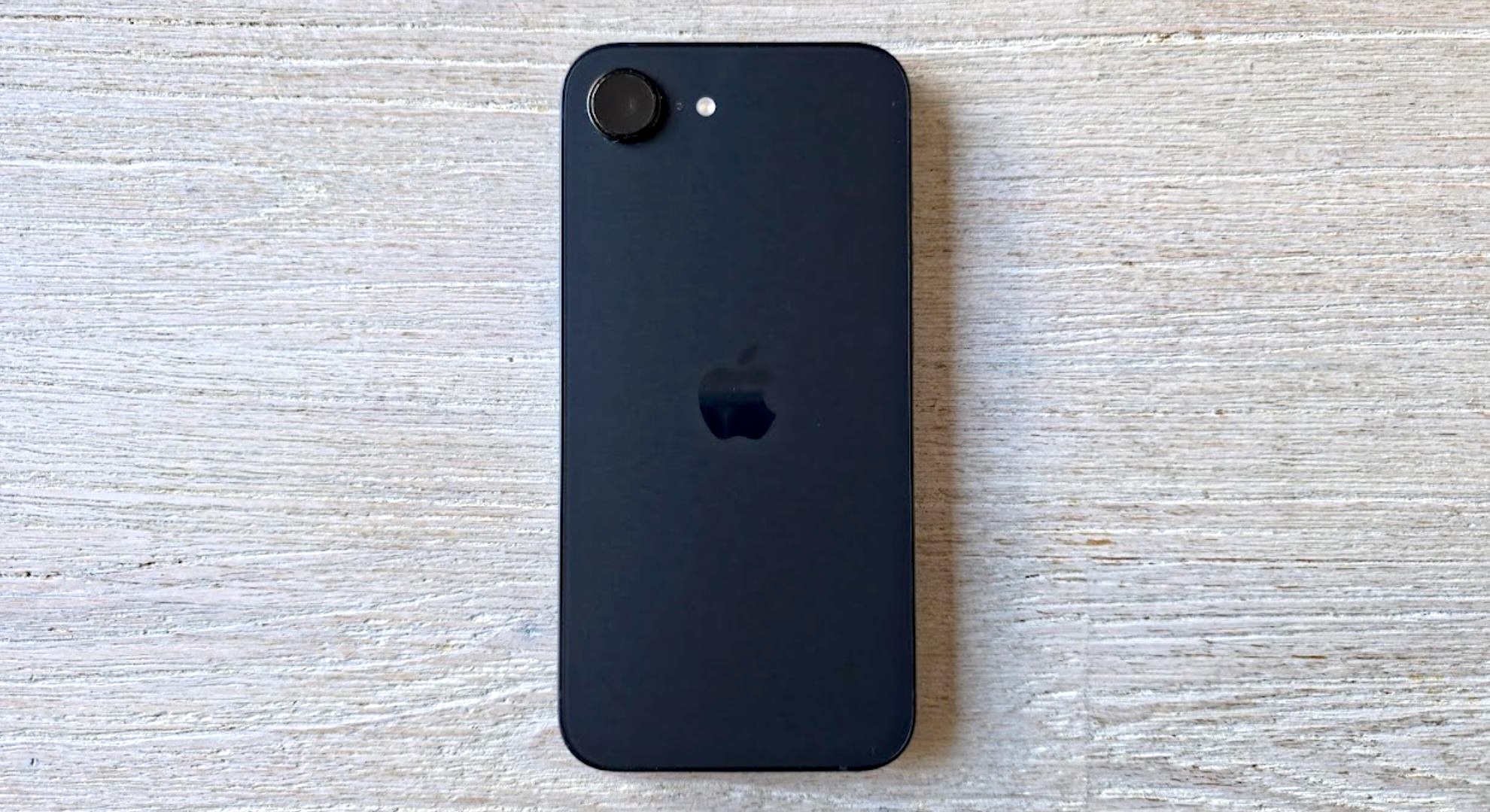 The iPhone 16e smartphone from the back lying on a table