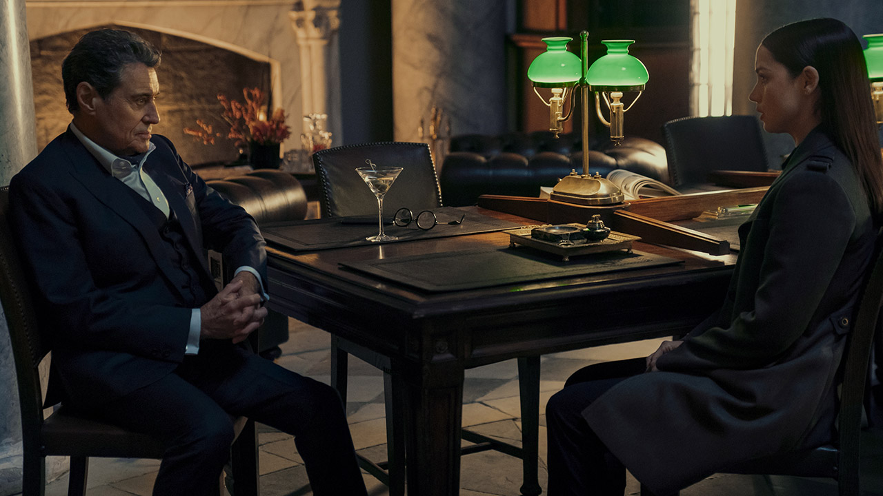 Winston sitting down at a table with Eve in From the World of John Wick: Ballerina